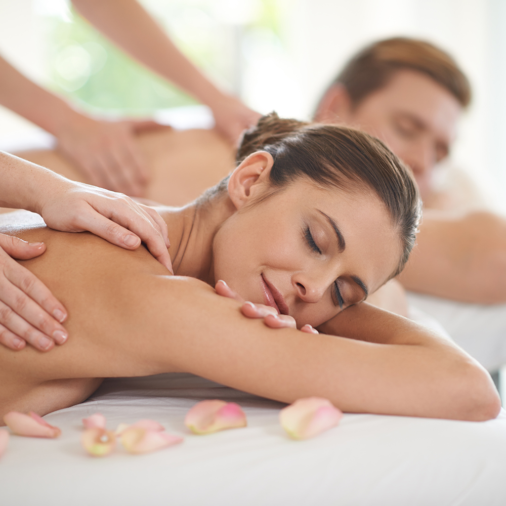 A husband and wife lying together on massage tables